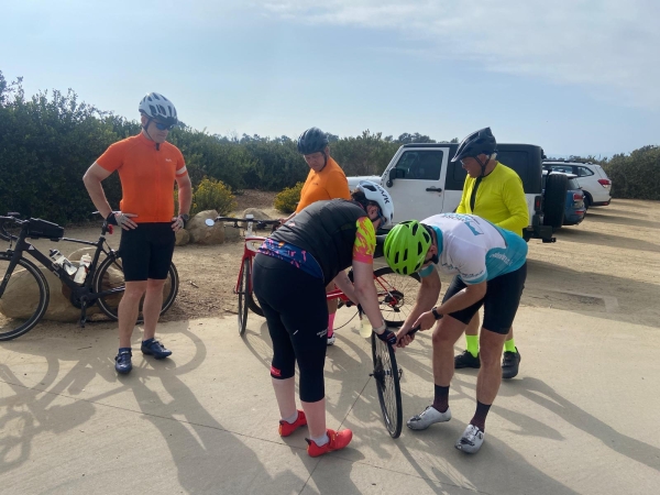 A leader fixing a bike at the roadside