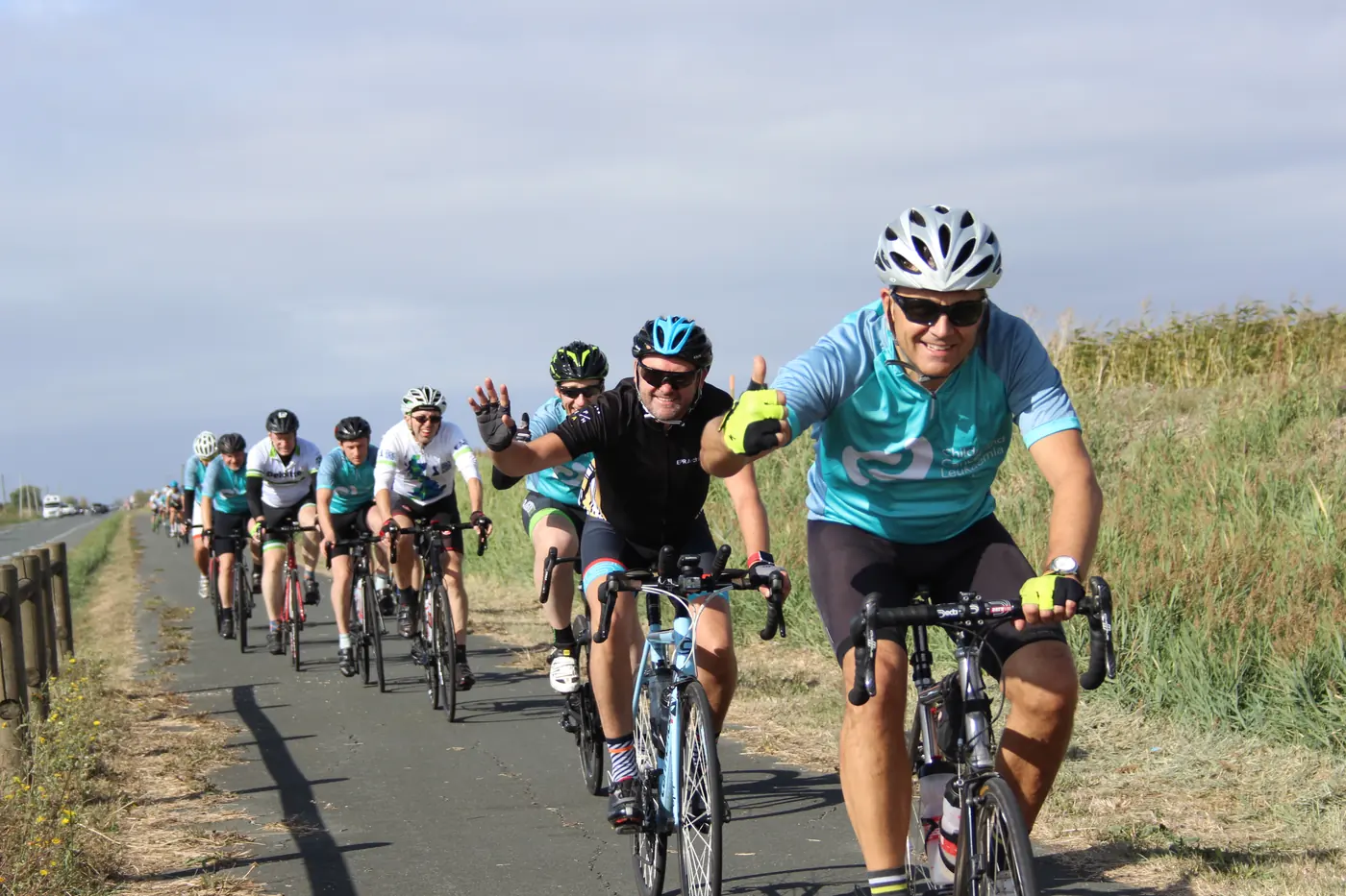 CCLG charity cyclists in matching jerseys riding together on a coastal path on their London to Bordeaux ride