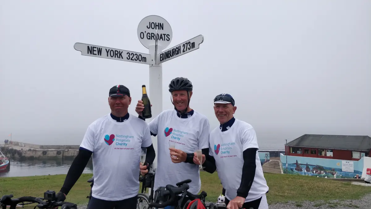 Nottingham Hospitals Charity riders at the John O'Groats signpost after cycling the length of Britain