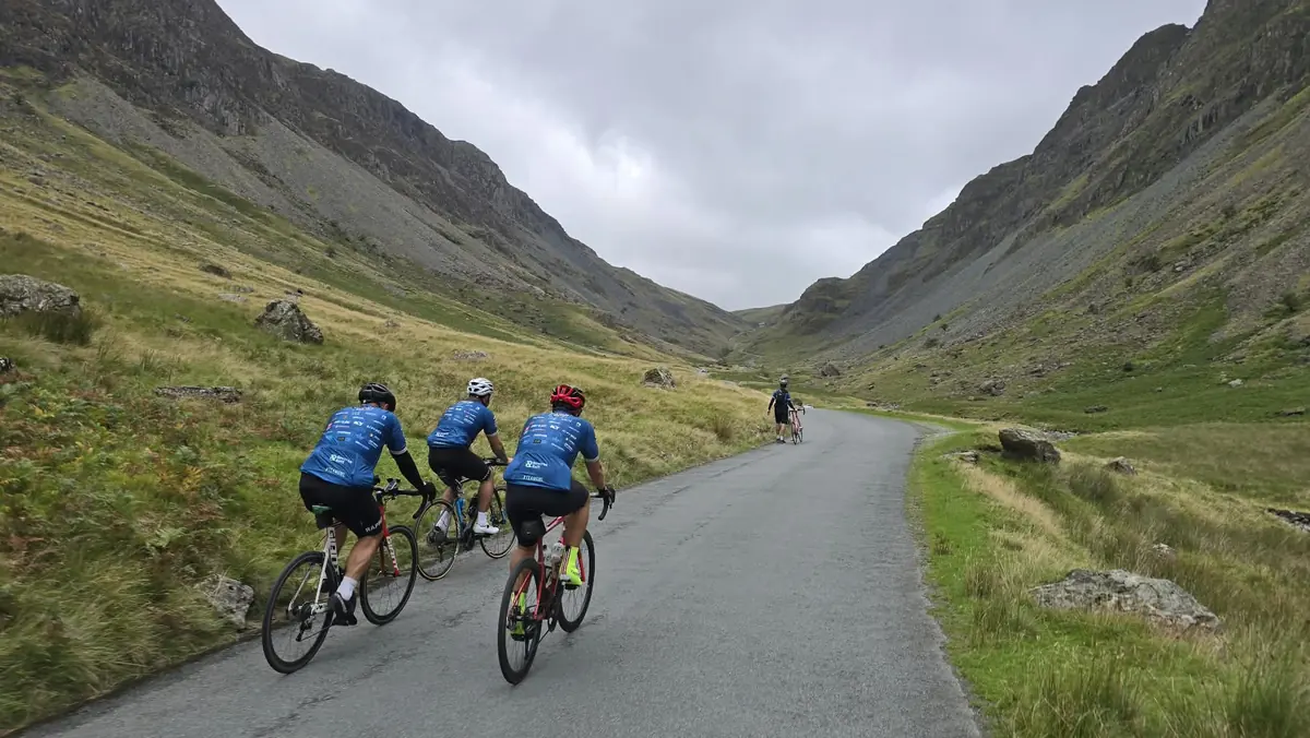 Reverse Rett charity cyclists riding through a Lake District valley