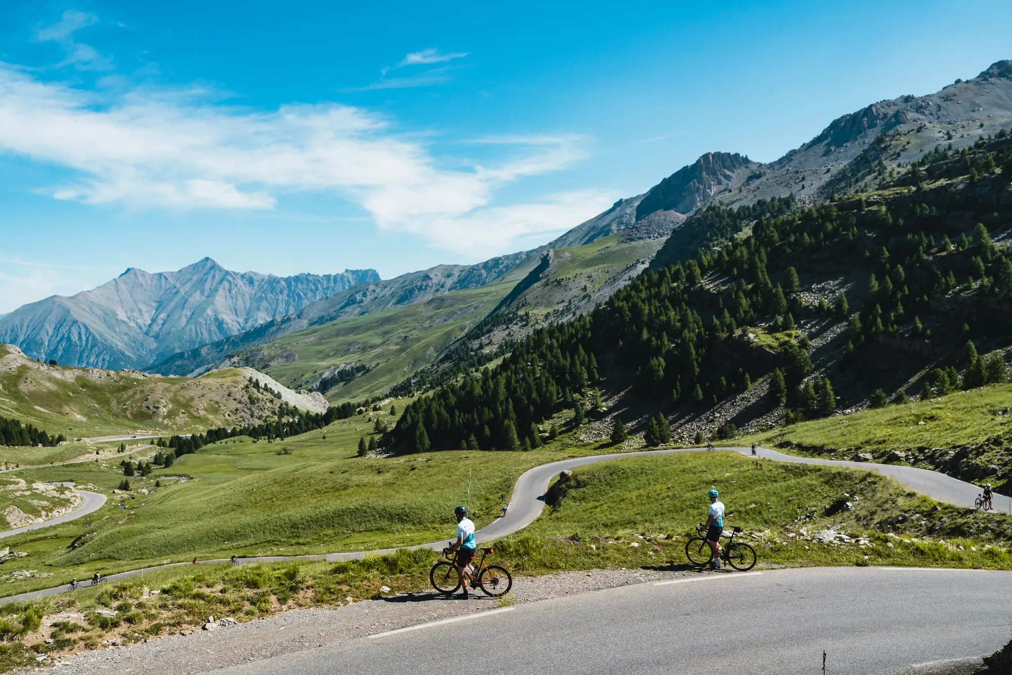 Riders above Alpine hairpins near Barcelonnette