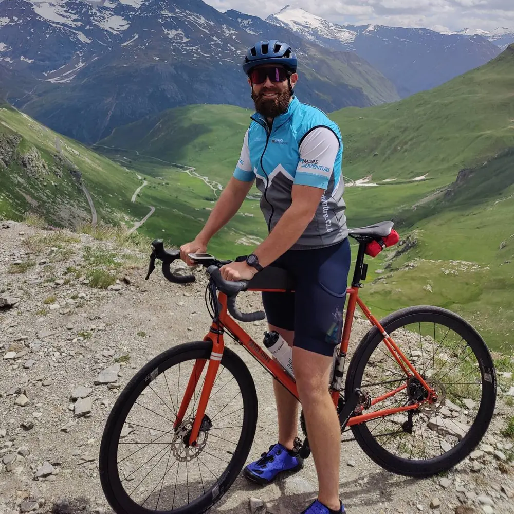 Rhys Jordan with his bike high in the Alps