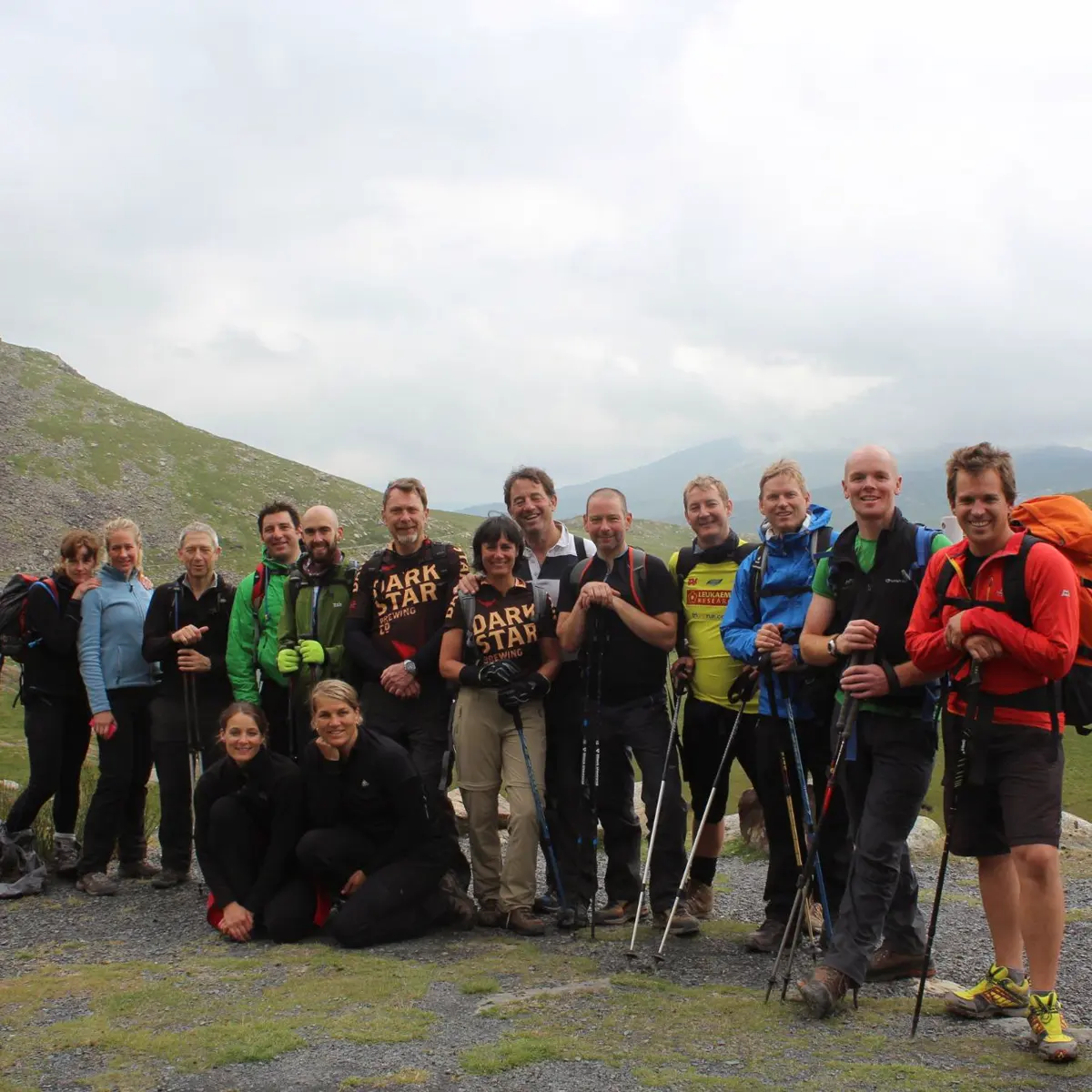 A smiling hiking group with walking poles in the mountains of Eryri (Snowdonia)