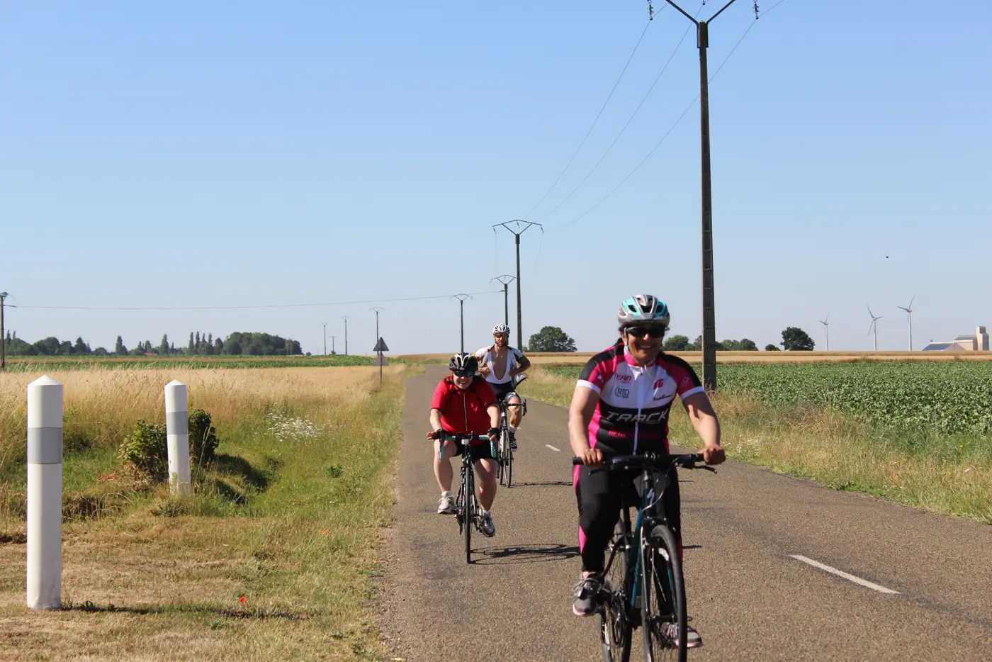 Dassault Systèmes riders waving on a quiet road through French farmland