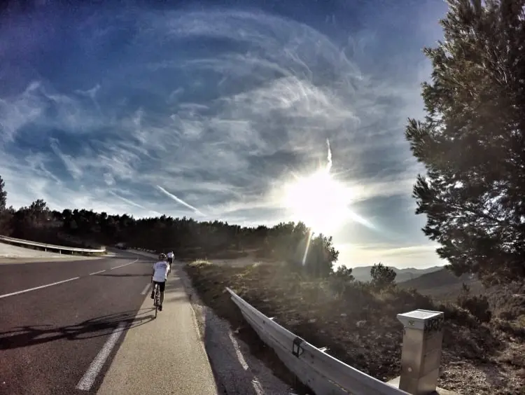 A cyclist on a sunlit coastal road in the south of France
