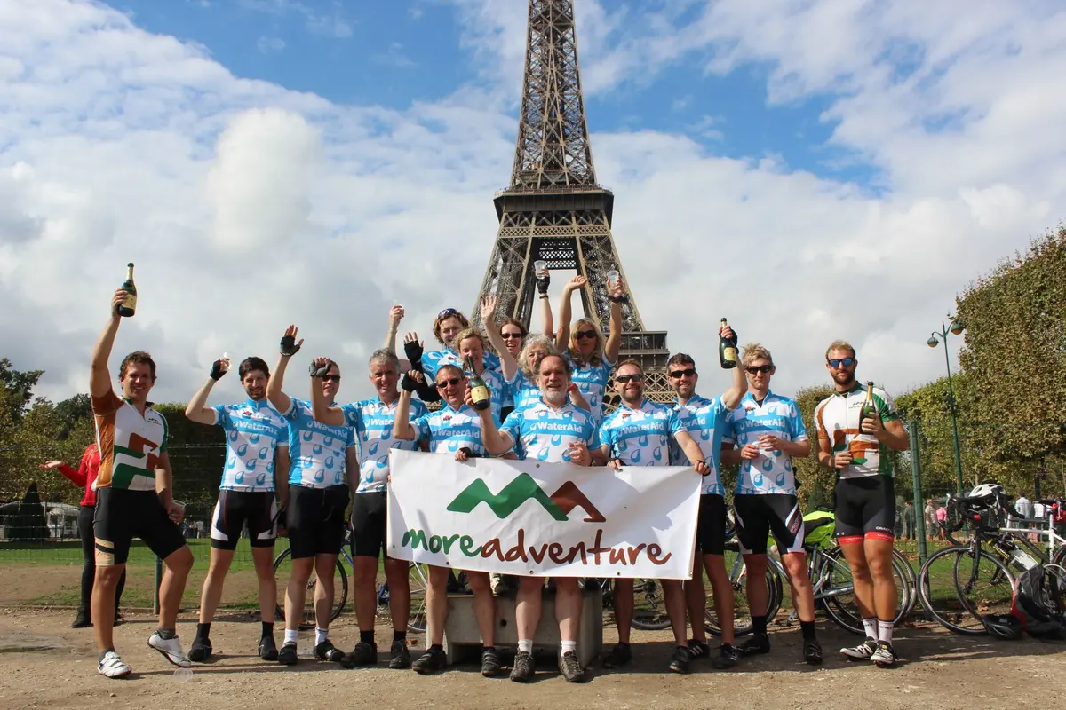 The Environment Agency charity team celebrating with champagne under the Eiffel Tower