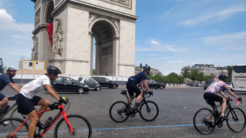 Cyclists riding past the Arc de Triomphe