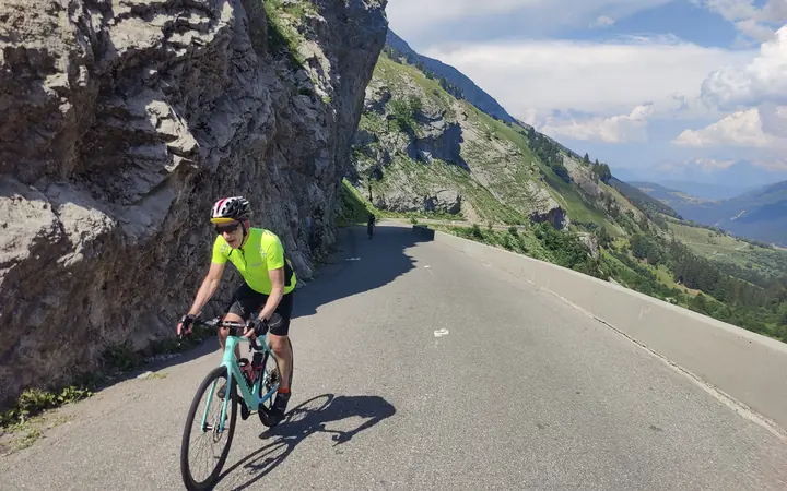 A cyclist climbing an Alpine pass on the Geneva to Nice cycle