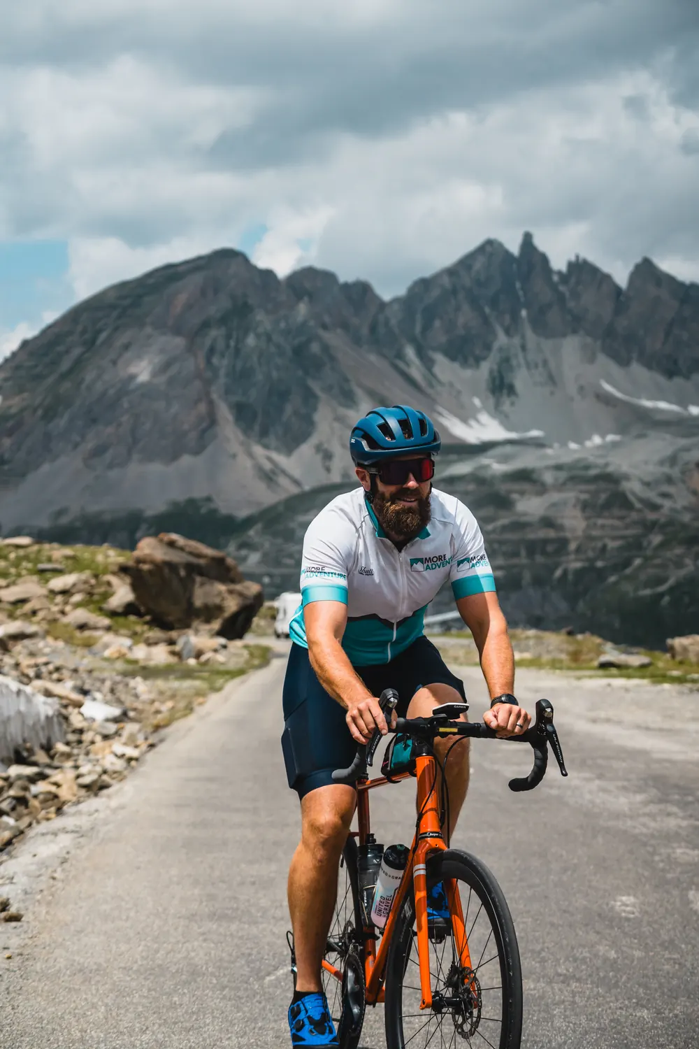 Rhys Jordan riding an Alpine pass beneath jagged peaks