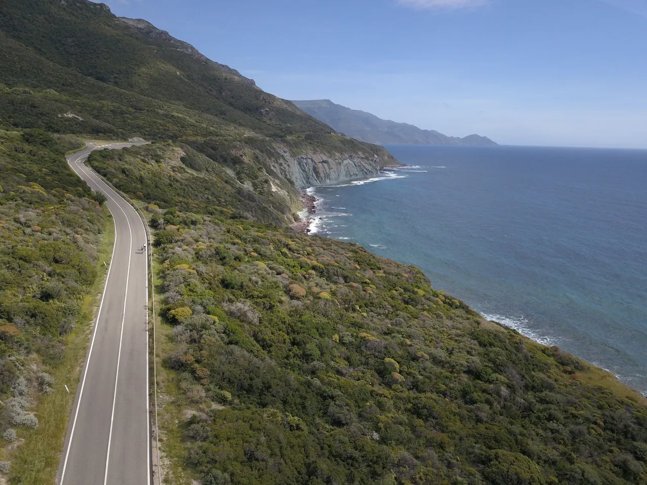 Two cyclists on a quiet coastal road above the sea on a More Adventure cycling holiday in Sardinia